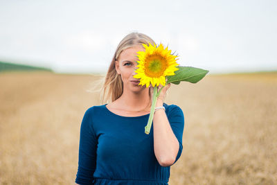 Woman standing in sunflower field