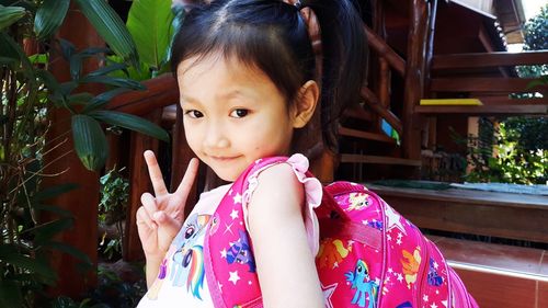 A four-year-old asian girl posing for two fingers