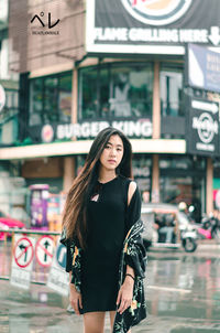 Portrait of beautiful young woman standing in city