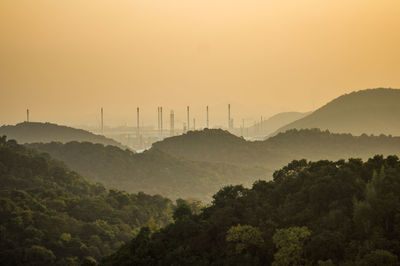 Silhouette trees and mountains against sky during sunset