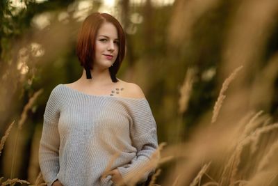 Portrait of young woman standing on field