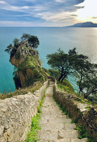 Footpath by sea against sky