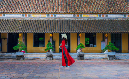 Rear view of woman standing outside temple