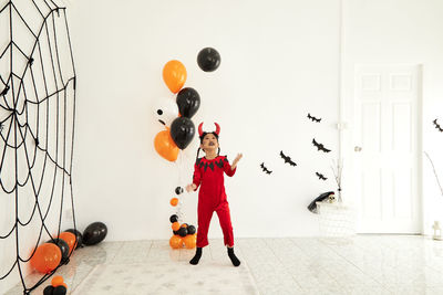Boy playing with balloons against wall