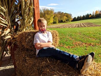 Portrait of boy sitting on a hay bale