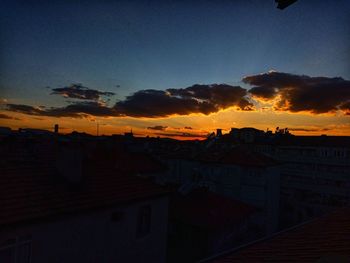 Silhouette buildings against sky at sunset