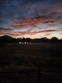 Scenic view of silhouette field against sky during sunset