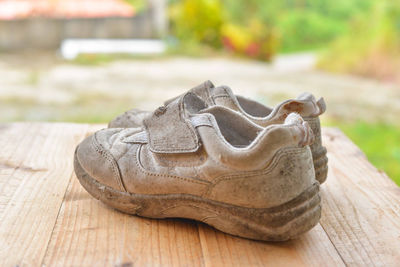 Close-up of old shoes on wooden table