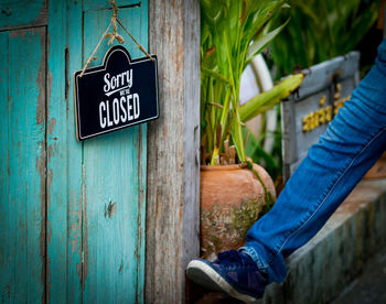 Low section of man with by wooden post