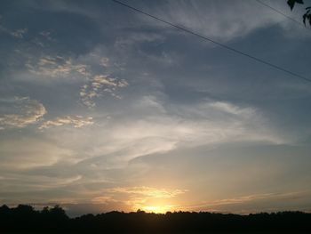 Low angle view of silhouette trees against sky