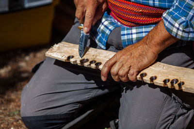 Midsection of man working on wood