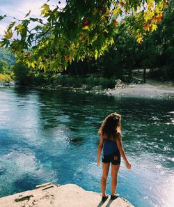 Full length of woman standing by river