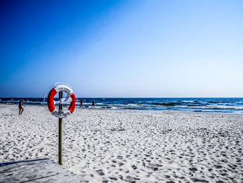 Lifeguard hut on beach against clear blue sky