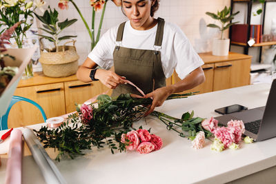 Female florist tying bouquet in shop