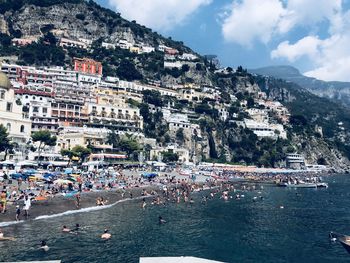 Aerial view of town by sea against sky