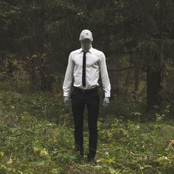 Man standing on field in forest