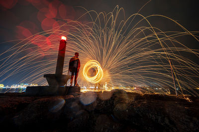 Man spinning wire wool at night