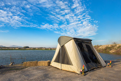 Tent on beach against blue sky