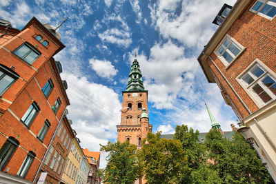 Low angle view of clock tower amidst buildings in city