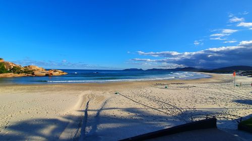 Scenic view of beach against blue sky