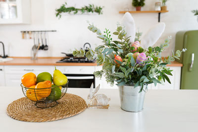 Easter bunny and flowers with eggs on white table in scandinavian-style kitchen.