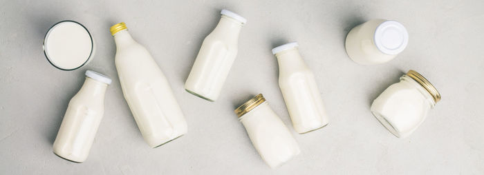 Directly above shot of milk bottles over white background