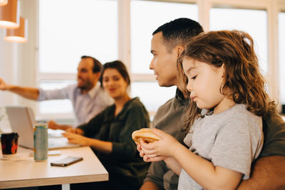 Friends looking at camera while sitting on table