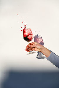 Person holding a glass of red wine
