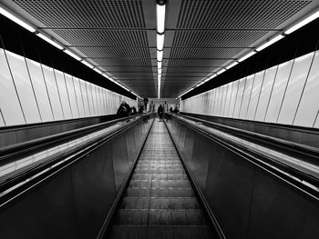 Low angle view of woman on illuminated escalator