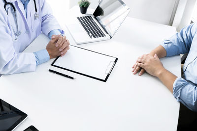 Midsection of man using laptop on table