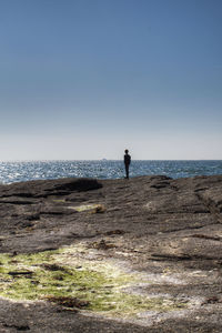 Man standing on beach against clear sky