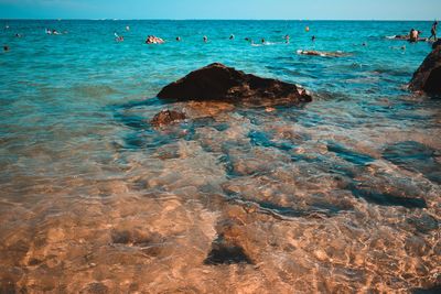 Scenic view of rocks in sea against sky