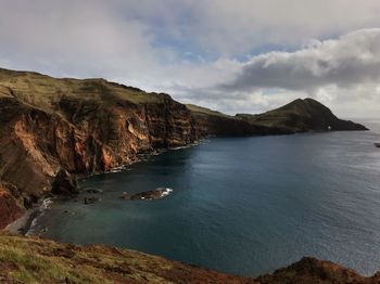 Scenic view of sea and mountains against sky