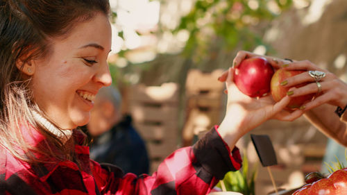Side view of woman holding apple