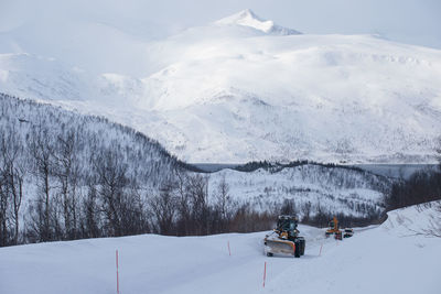 Snow covered field against snowcapped mountain