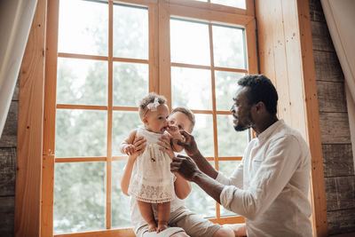 Father and son standing by window