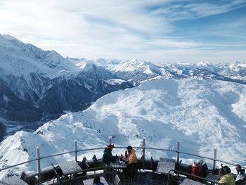 High angle view of people at balcony against snowcapped mountains