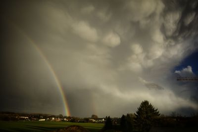 Rainbow over landscape against sky