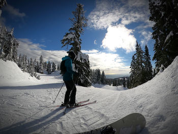 Girl skiing on snowcapped mountain against sky
