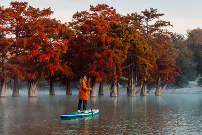 Rear view of woman standing in lake