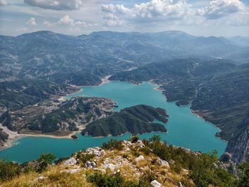 High angle view of sea and mountains against sky