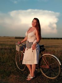 Full length of woman standing on field against sky