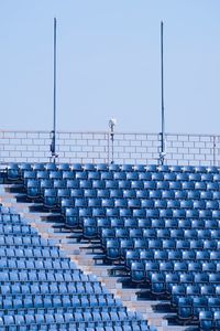 Empty chairs against clear blue sky