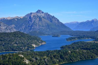 Scenic view of lake and mountains against blue sky