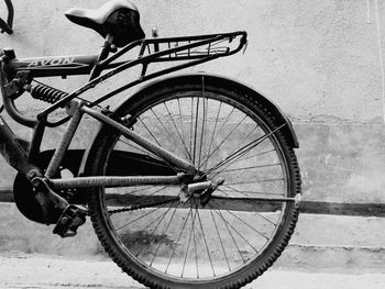 Side view of bicycle on street against wall