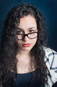 Portrait of smiling young woman against gray background