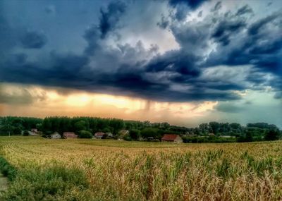 Scenic view of field against cloudy sky