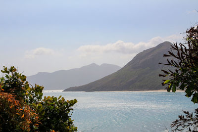 Scenic view of sea and mountains against sky