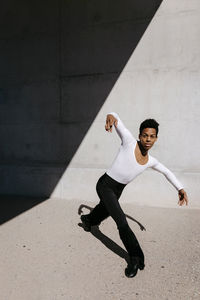 Flexible man dancing against wall