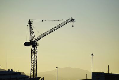 Low angle view of cranes against clear sky